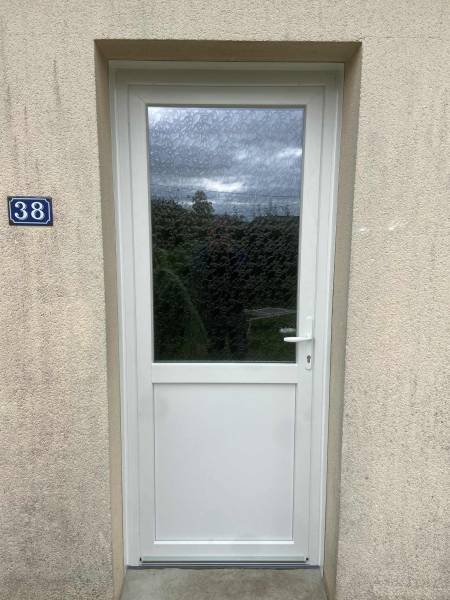 Remplacement d'une porte d'entrée vétuste bois par une porte d'entrée en PVC blanc soubassement plein isolé, vitrage haut sur le secteur Fécamp (76)