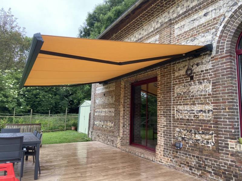 Menuisier pour l'installation d'un store banne électrique de chez EUROCOM STORES, coffre gris et toile RAL 6318 secteur Yvetot (76)