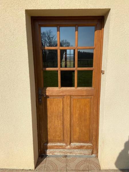 Artisan menuisier pour l'installation d'une porte d'entrée en PVC blanc avec soubassement plein et vitrage haut clair avec petits bois secteur Limpiville (76)
