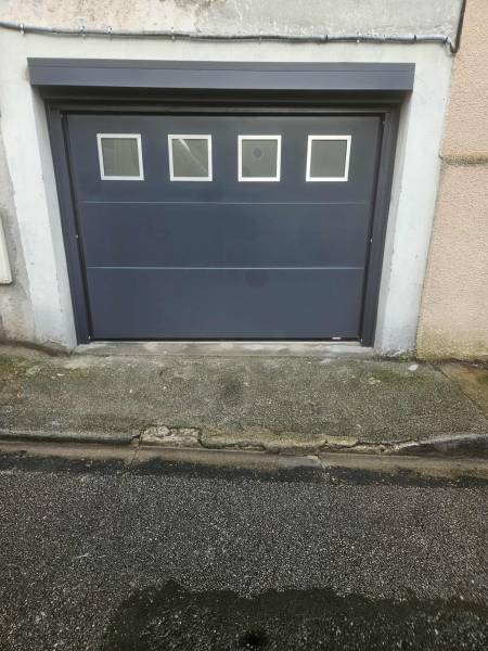 Remplacement d'une porte de garage vétuste par une porte de garage sectionnelle motorisée de chez GARATEC en RAL 7016 sur Fécamp (76)